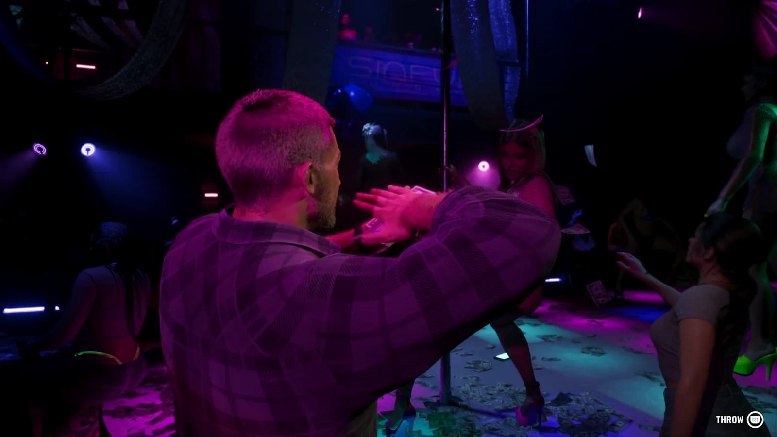Dentro il locale notturno, illuminato da luci viola e blu, un uomo sferra un pugno mentre altre persone si muovono sullo sfondo tra la folla.