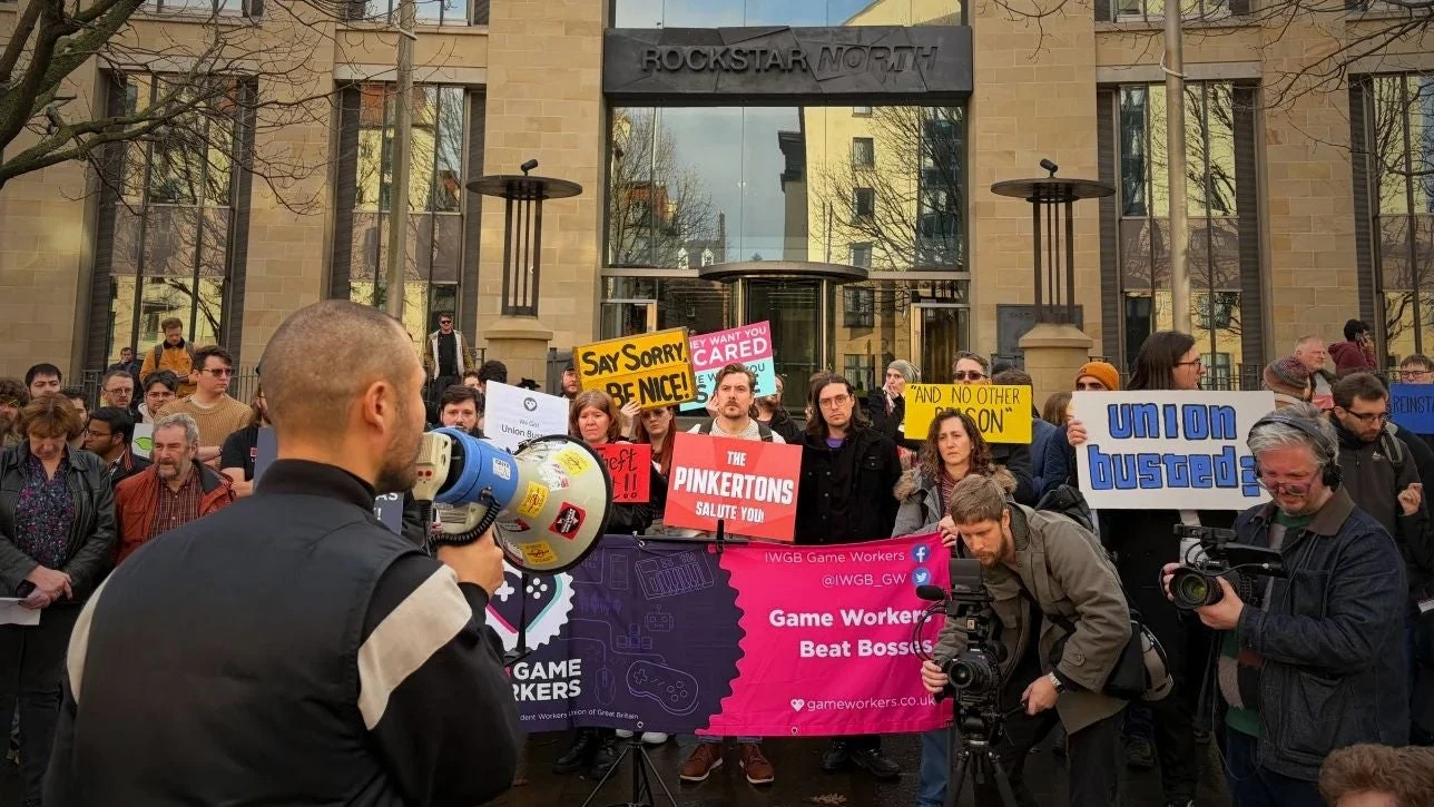 Un manifestante parla al megafono davanti allo studio Rockstar North durante una protesta del sindacato.