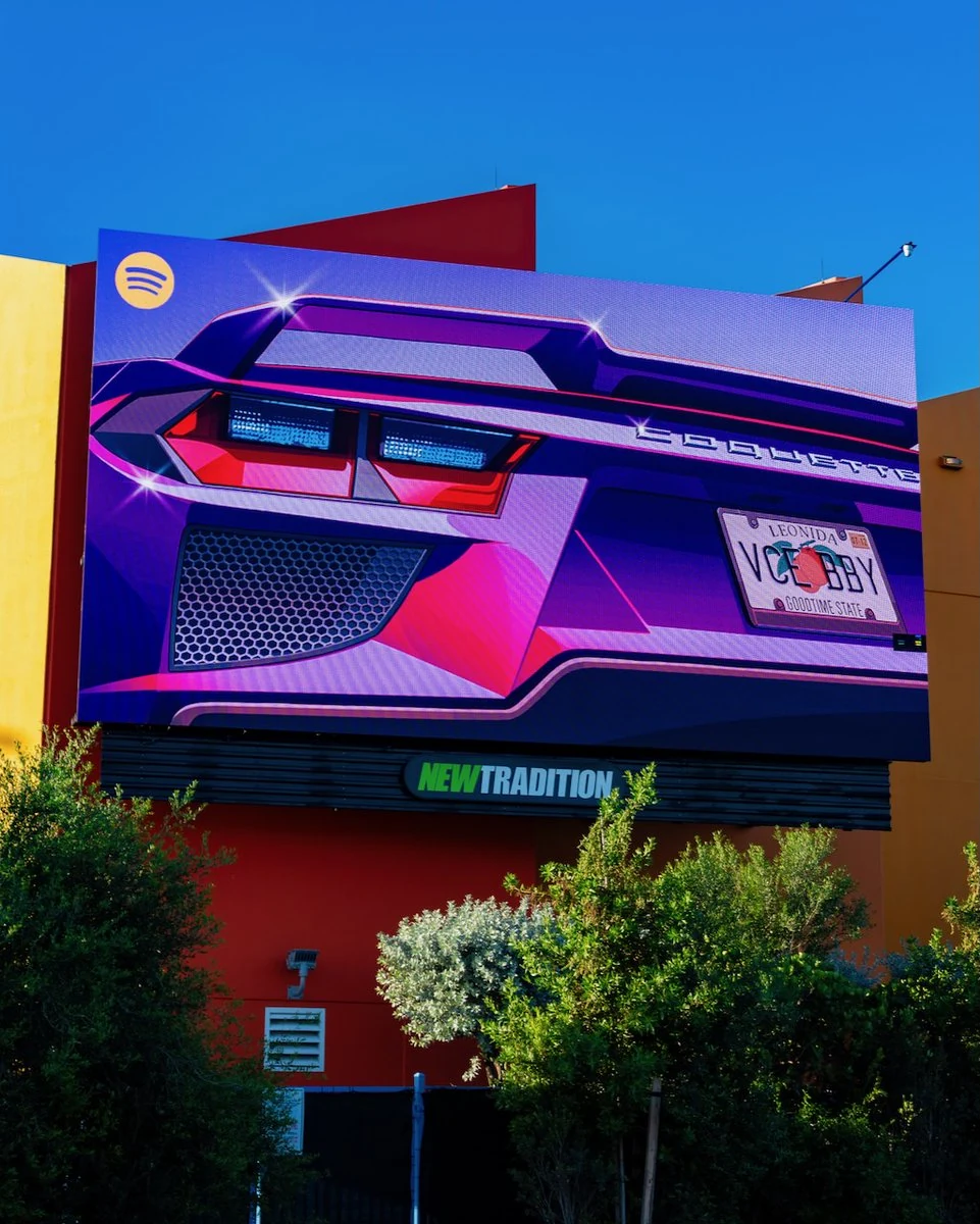 Un cartellone di GTA VI con un’auto e il logo Spotify su una facciata arancione.